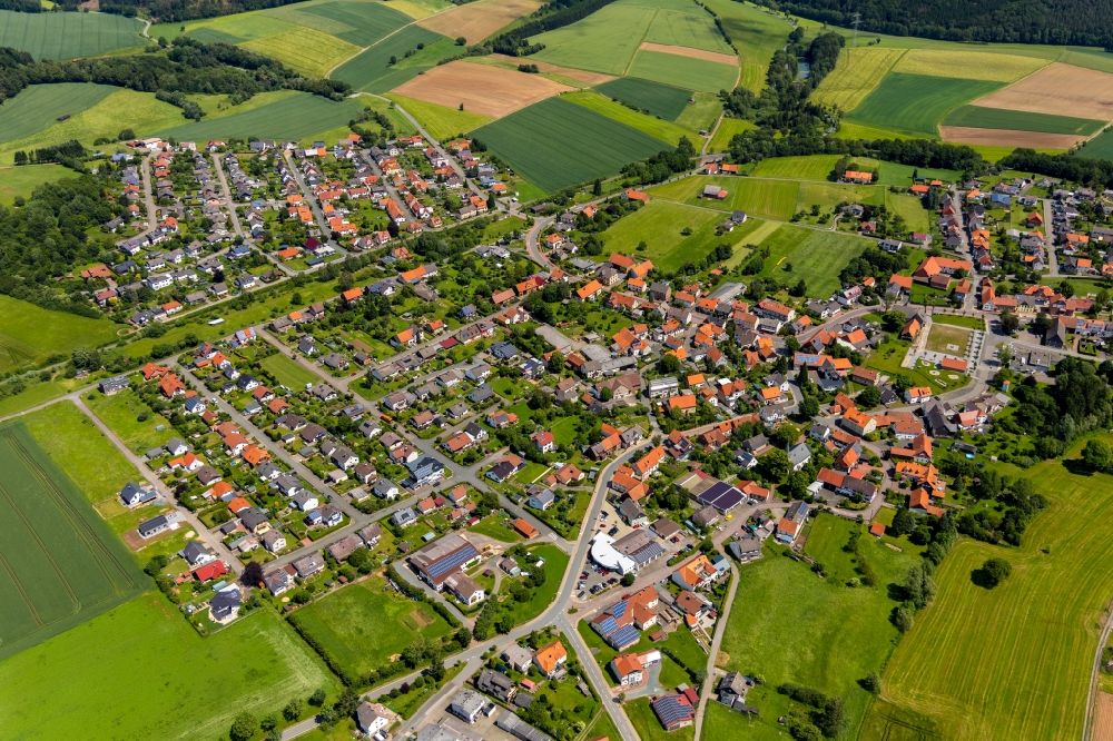 Höringhausen from above - Agricultural land and field borders surround the settlement area of the village in Hoeringhausen in the state Hesse, Germany
