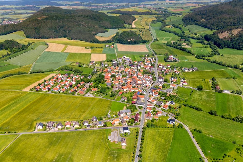 Kleinern from the bird's eye view: Agricultural land and field borders surround the settlement area of the village in Kleinern in the state Hesse, Germany