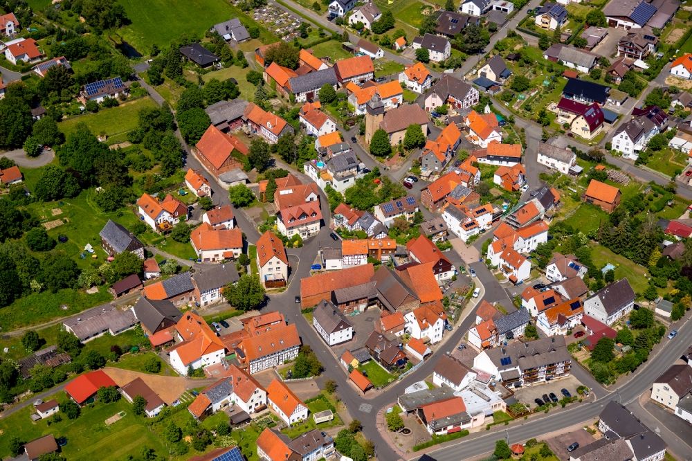 Kleinern from above - Agricultural land and field borders surround the settlement area of the village in Kleinern in the state Hesse, Germany