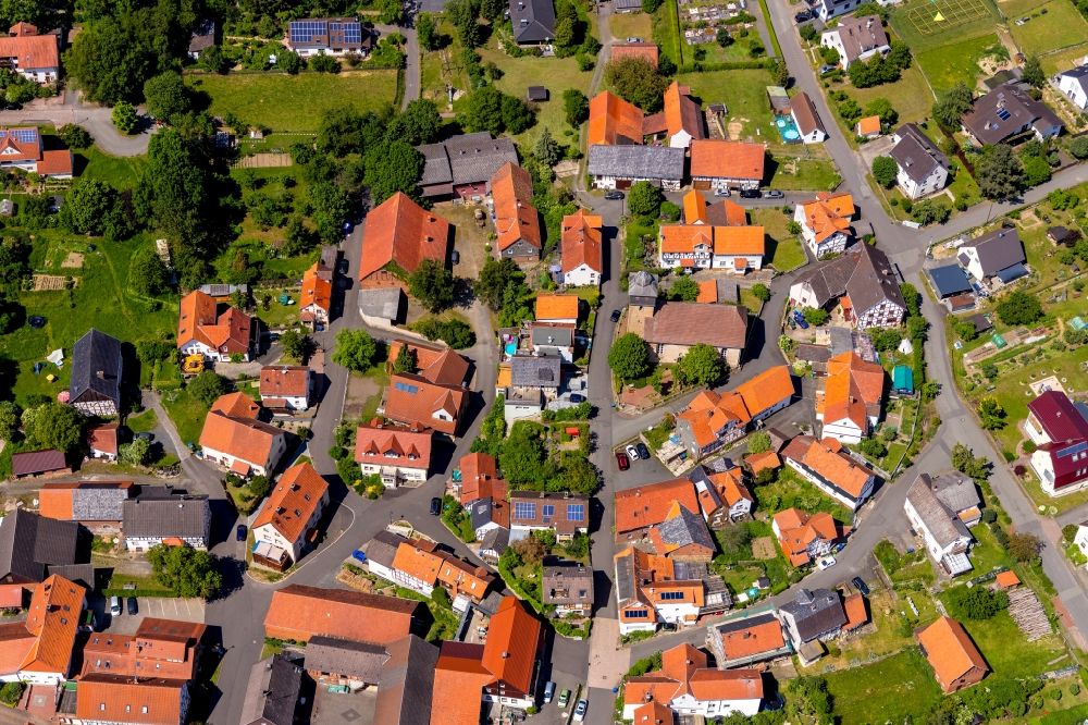 Kleinern from the bird's eye view: Agricultural land and field borders surround the settlement area of the village in Kleinern in the state Hesse, Germany