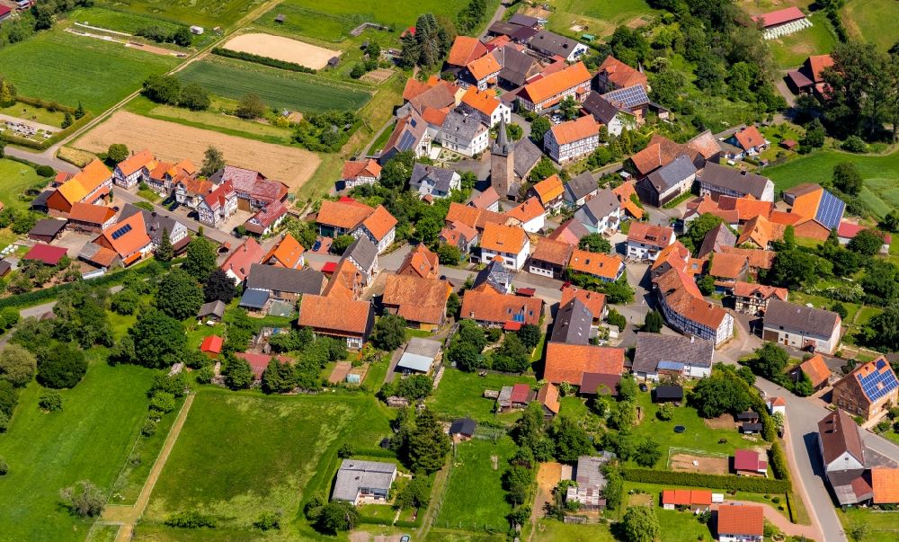 Aerial image Königshagen - Agricultural land and field borders surround the settlement area of the village in Koenigshagen in the state Hesse, Germany