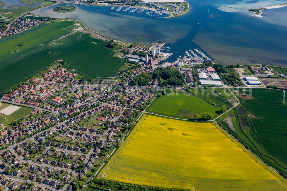Fehmarn from the bird's eye view: Village center on the sea coast area of the Baltic Sea island in Fehmarn in the state Schleswig-Holstein, Germany. Residential area, agriculture and port -facilities with warehouse -logistics