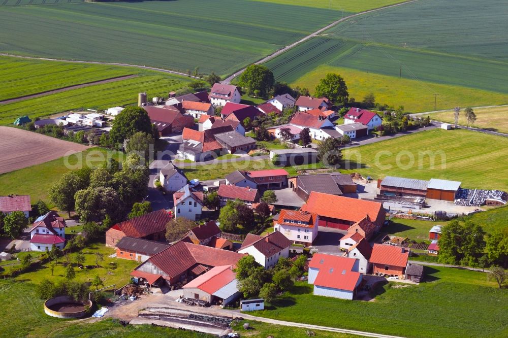 Mengers from the bird's eye view: Agricultural land and field borders surround the settlement area of the village in Mengers in the state Hesse, Germany