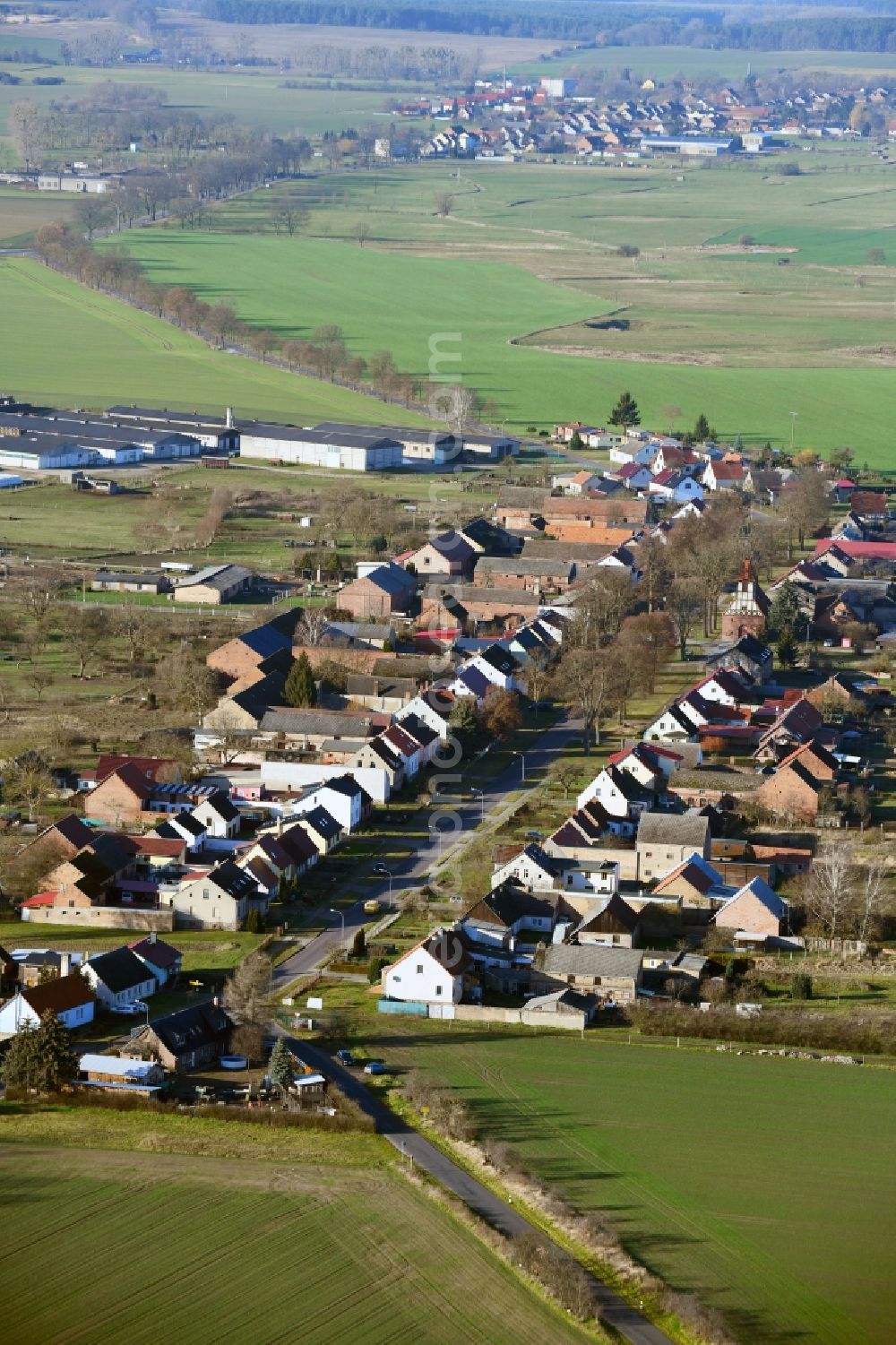 Aerial image Neulögow - Agricultural land and field borders surround the settlement area of the village in Neuloegow in the state Brandenburg, Germany
