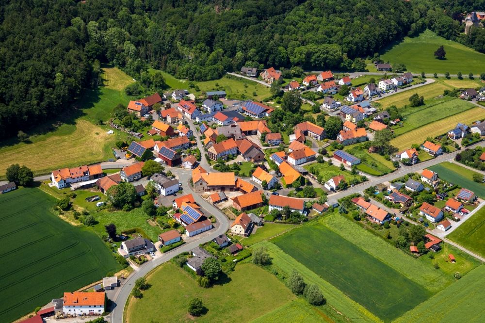 Nieder-Ense from the bird's eye view: Agricultural land and field borders surround the settlement area of the village in Nieder-Ense in the state Hesse, Germany