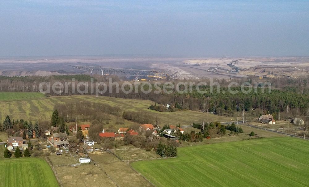 Proschim from the bird's eye view: Agricultural land and field borders surround the settlement area of the village in Proschim in the state Brandenburg, Germany