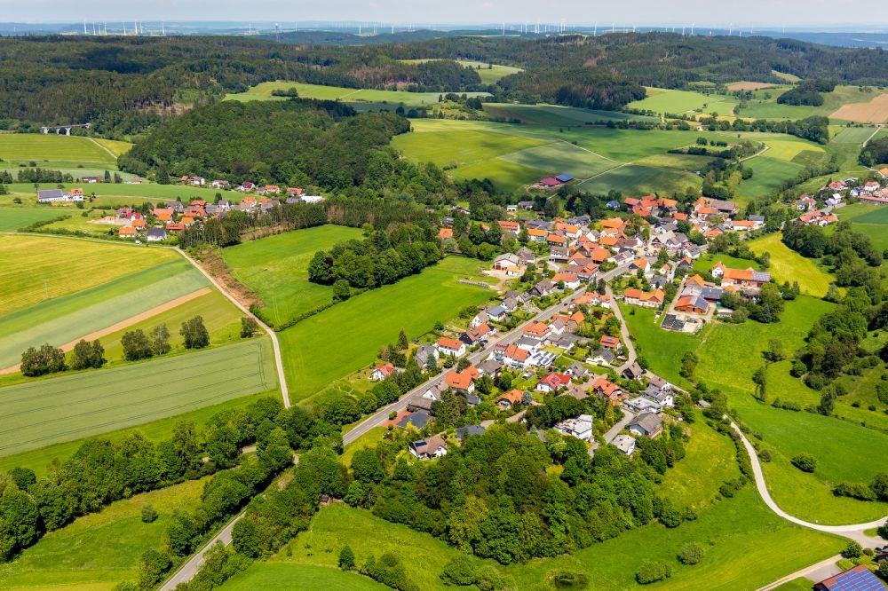 Rhena from the bird's eye view: Agricultural land and field borders surround the settlement area of the village in Rhena in the state Hesse, Germany