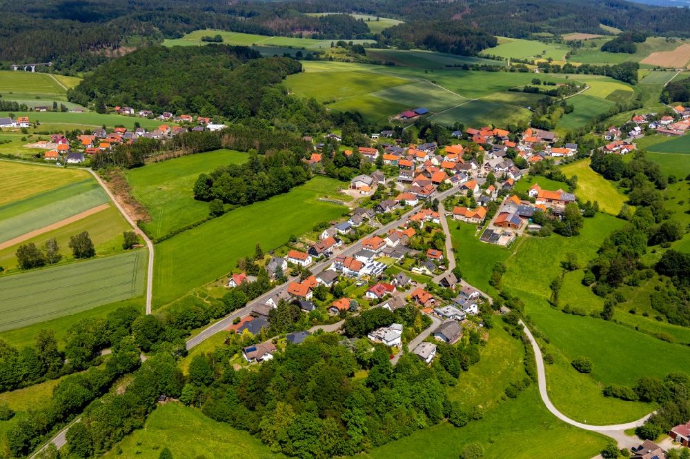 Aerial image Rhena - Agricultural land and field borders surround the settlement area of the village in Rhena in the state Hesse, Germany