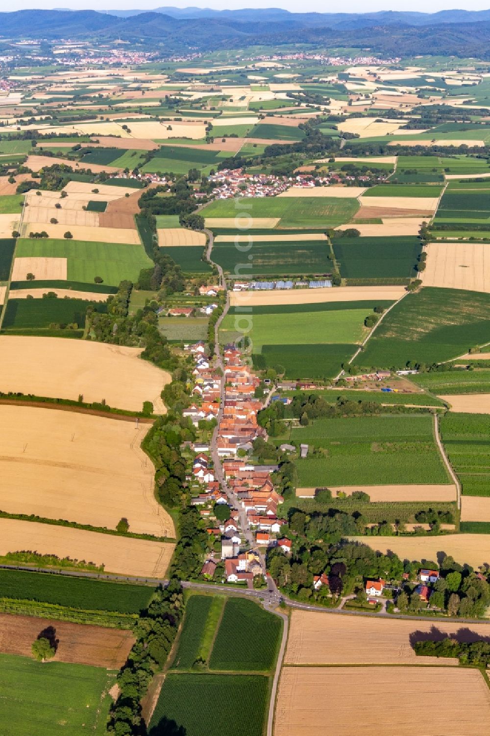 Vollmersweiler from the bird's eye view: Agricultural land and field borders surround the settlement area of the village in Vollmersweiler in the state Rhineland-Palatinate, Germany
