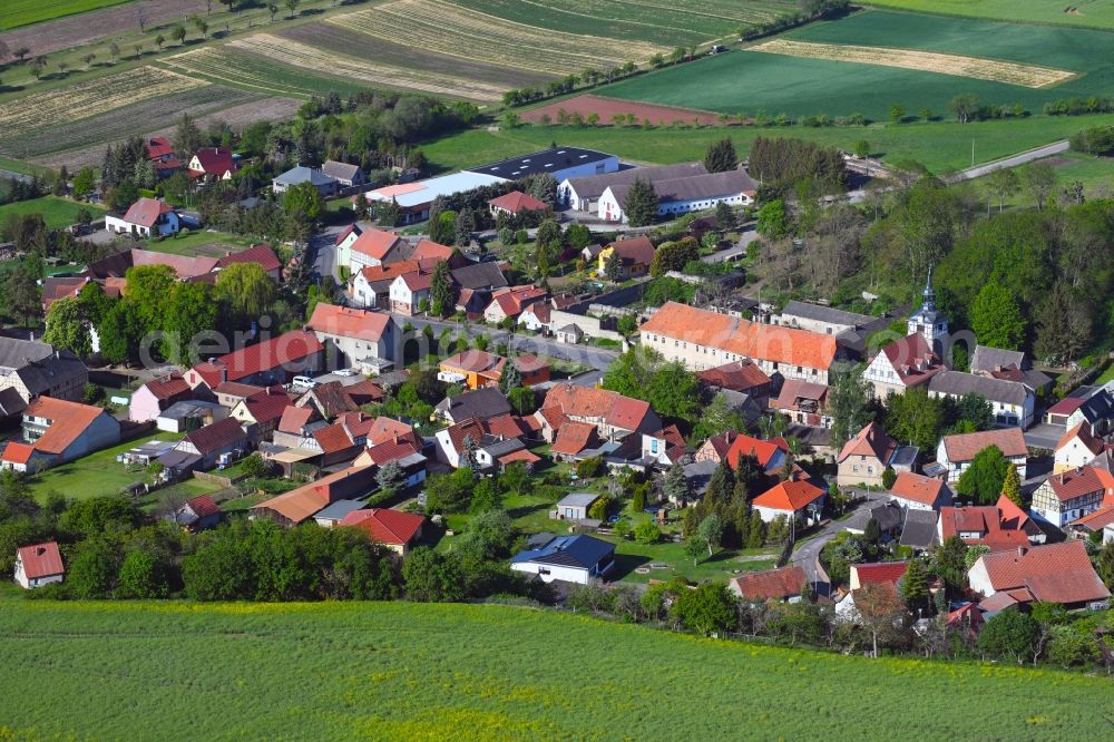 Wickerode from above - Agricultural land and field borders surround the settlement area of the village in Wickerode in the state Saxony-Anhalt, Germany