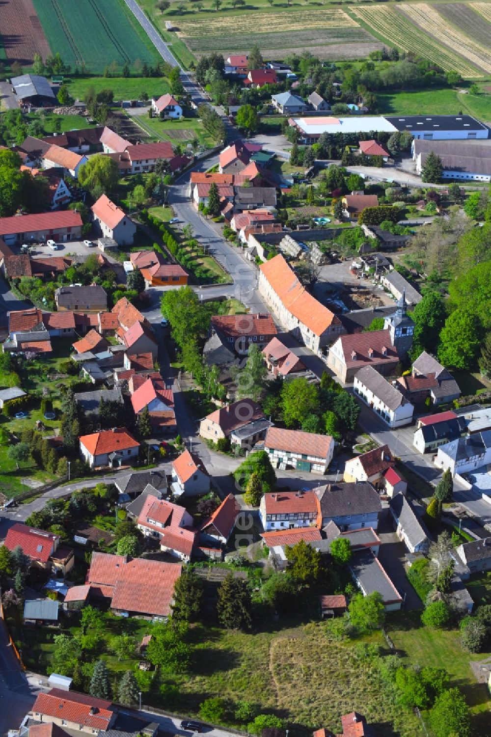 Aerial image Wickerode - Agricultural land and field borders surround the settlement area of the village in Wickerode in the state Saxony-Anhalt, Germany