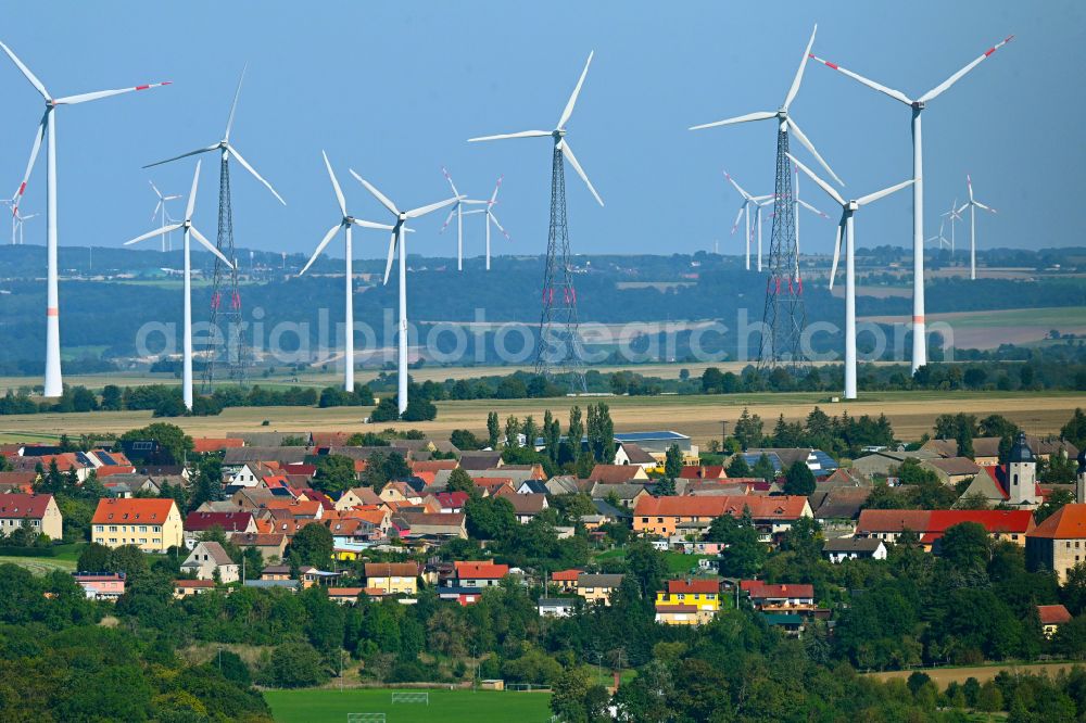 Frauenprießnitz from the bird's eye view: Agricultural areas and field boundaries with wind turbines surround the settlement area of the village in Frauenpriessnitz in the state Thuringia, Germany