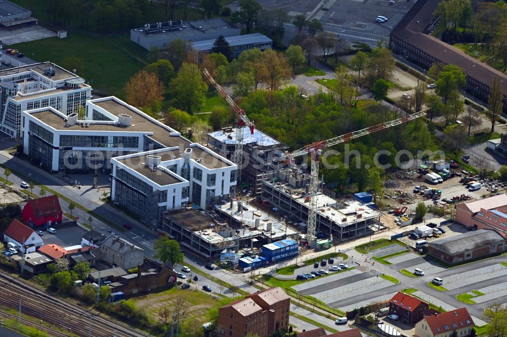 Schönefeld from above - Construction site for the new residential and commercial Corner house - building BB Business Hub on Mittelstrasse corner Kurzer Weg in Schoenefeld in the state Brandenburg, Germany