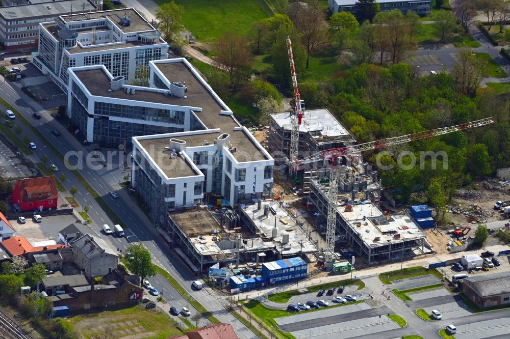 Schönefeld from the bird's eye view: Construction site for the new residential and commercial Corner house - building BB Business Hub on Mittelstrasse corner Kurzer Weg in Schoenefeld in the state Brandenburg, Germany