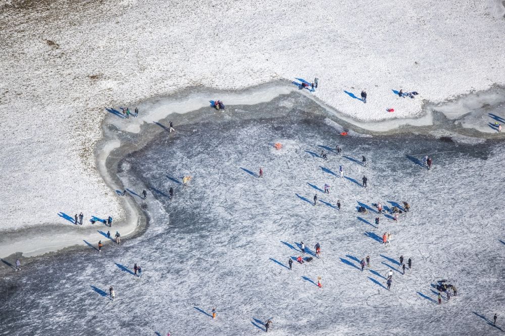 Düsseldorf from above - Walkers and passers-by walk on the ice sheet of the frozen bank areas in the course of the river of the Rhine river in the district Niederkassel in Duesseldorf in the state North Rhine-Westphalia, Germany