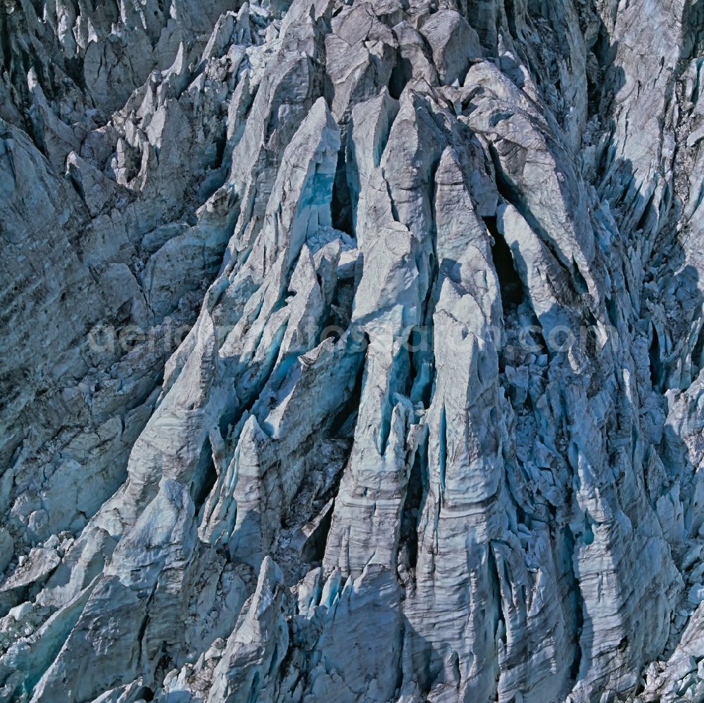 Aerial image Grindelwald - The rubble, which kept gathering on the ice over the centuries appears as if there were dark stripes in the walls. These ice giants are short-lived though. As the glacier slowly creeps downhill, they collaps