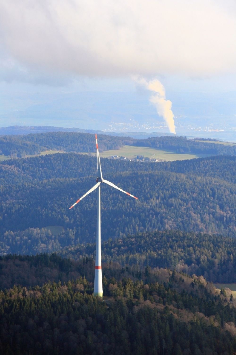 Schopfheim from above - Wind turbines of the wind farm Rohrenkopf in the Black Forest in Gersbach in the state Baden-Wurttemberg, Germany. In the background the steam column of swiss nuclear power plant Leibstadt KKL. Symbolic image for the controversial debate of nuclear power versus renewable power