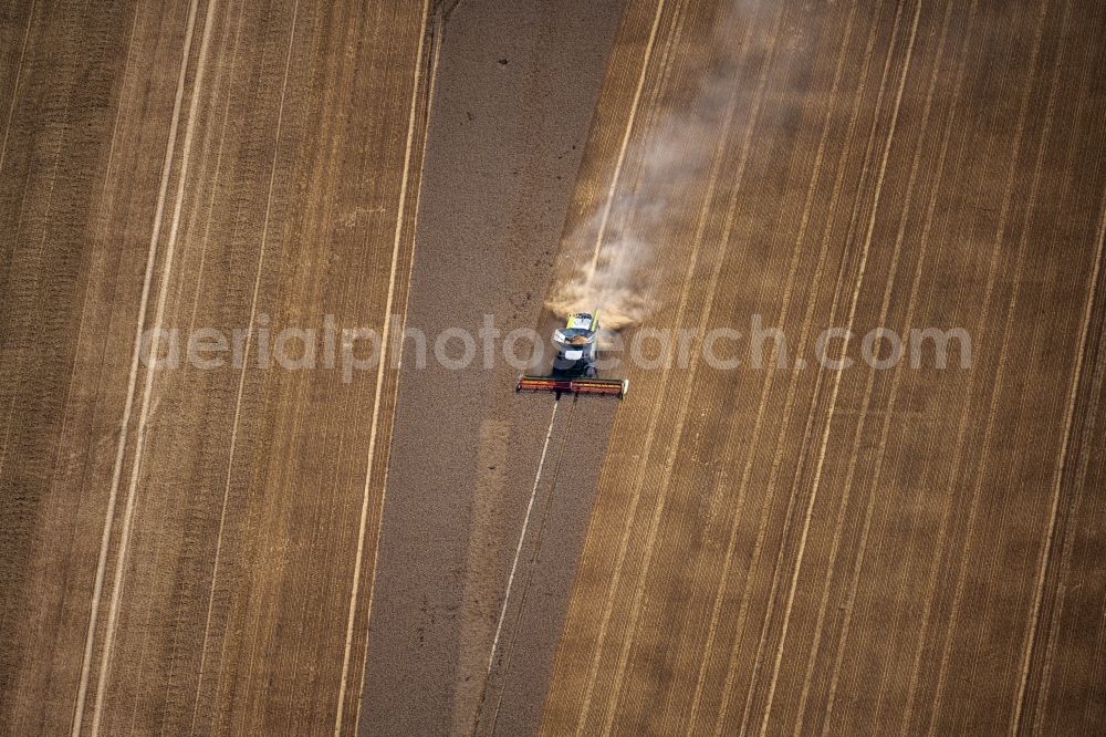 Broitzem from above - Harvest use of heavy agricultural machinery - combine harvesters and harvesting vehicles on agricultural fields in Broitzem in the state Lower Saxony, Germany