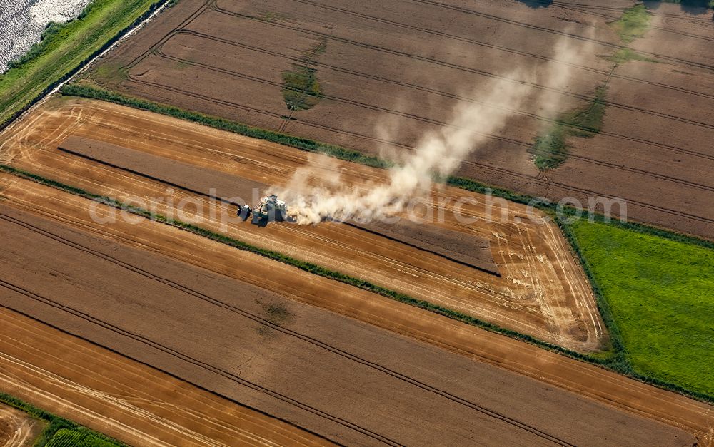 Aerial photograph Friedrichstadt - Harvest use of heavy agricultural machinery - combine harvesters and harvesting vehicles on agricultural fields in Friedrichstadt in the state Schleswig-Holstein, Germany