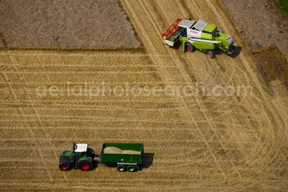 Aerial image Fuldabrück - Harvest use of heavy agricultural machinery - combine harvesters and harvesting vehicles on agricultural fields in Fuldabrueck in the state Hesse, Germany