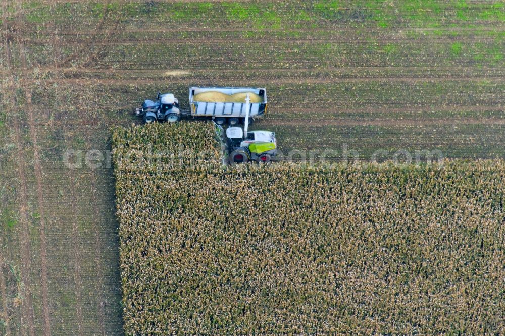 Aerial image Rotzendorf - Harvest use of heavy agricultural machinery - combine harvesters and harvesting vehicles on agricultural fields in Rotzendorf in the state Bavaria, Germany