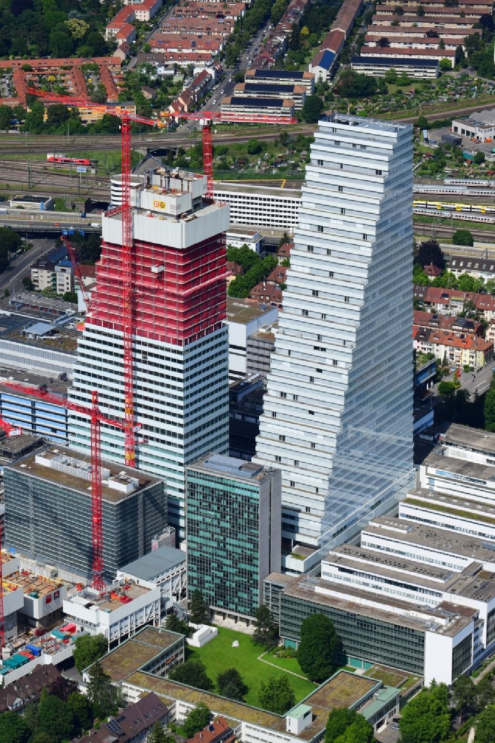 Aerial photograph Basel - Extension construction sites on the premises of the pharmaceutical company Roche with the cityscape-defining high-rise building in Basel in Switzerland. Construction works for the second tower are visible