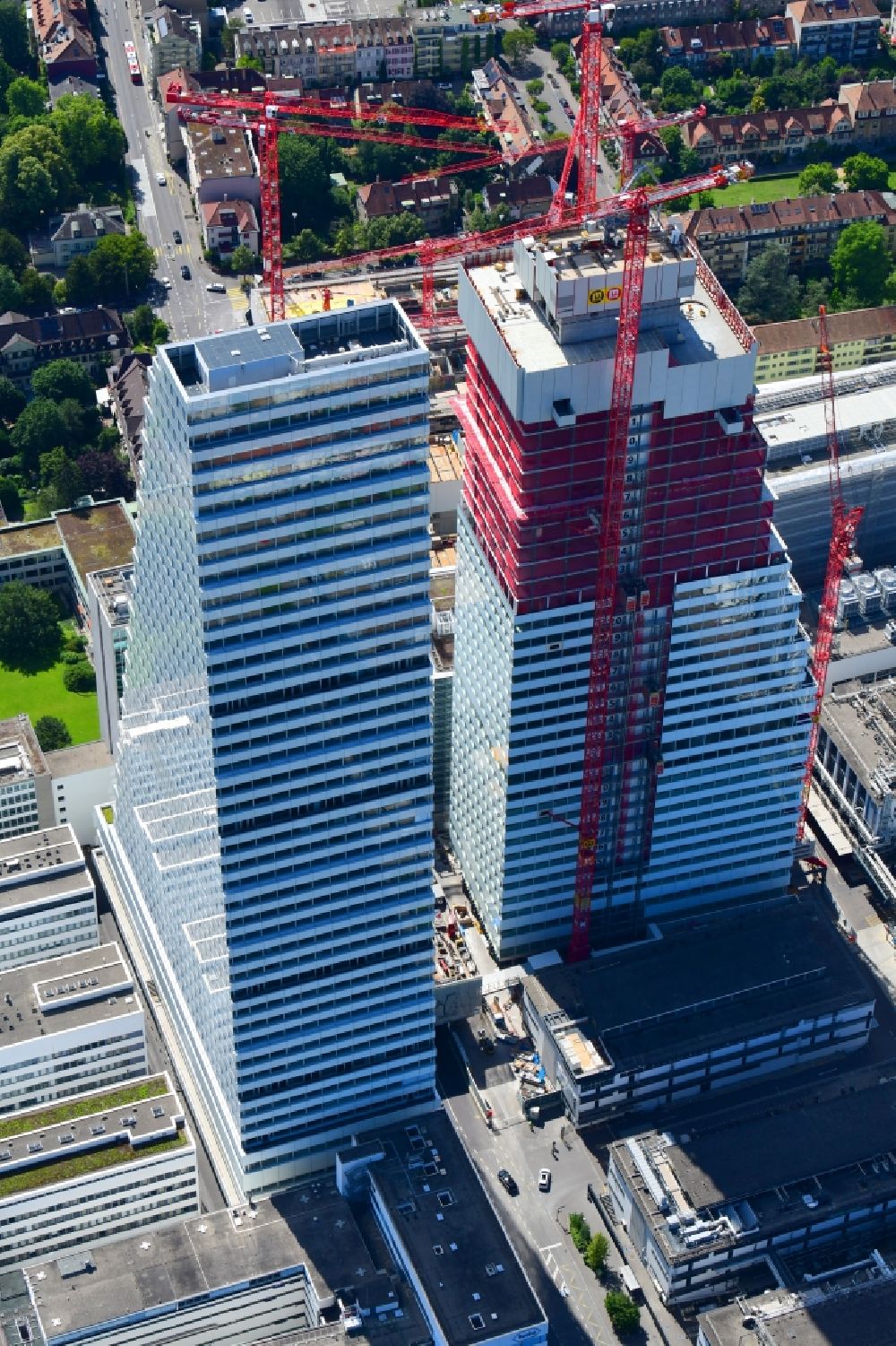 Aerial photograph Basel - Extension construction sites on the premises of the pharmaceutical company Roche with the cityscape-defining high-rise building in Basel in Switzerland. Construction works for the second tower are visible