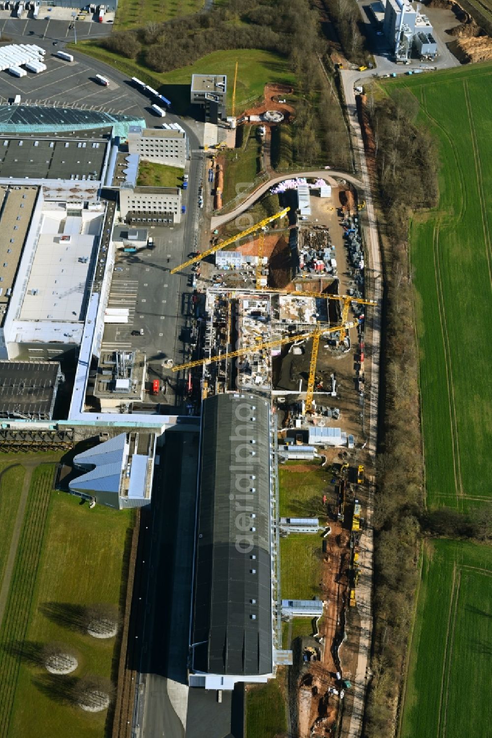 Melsungen from the bird's eye view: Extension - new building - construction site on the factory premises of B. Braun Melsungen AG on Carl-Braun-Strasse in the district Adelshausen in Melsungen in the state Hesse, Germany