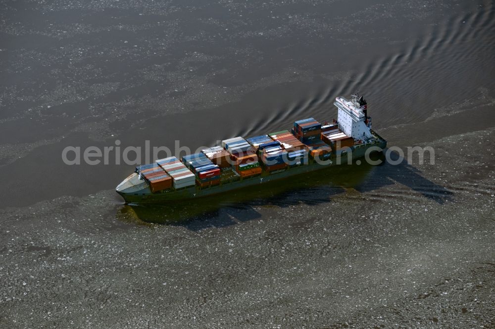 Aerial image Hetlingen - Sailing container ship on the Elbe - course of the river in Hetlingen in the state Schleswig-Holstein, Germany