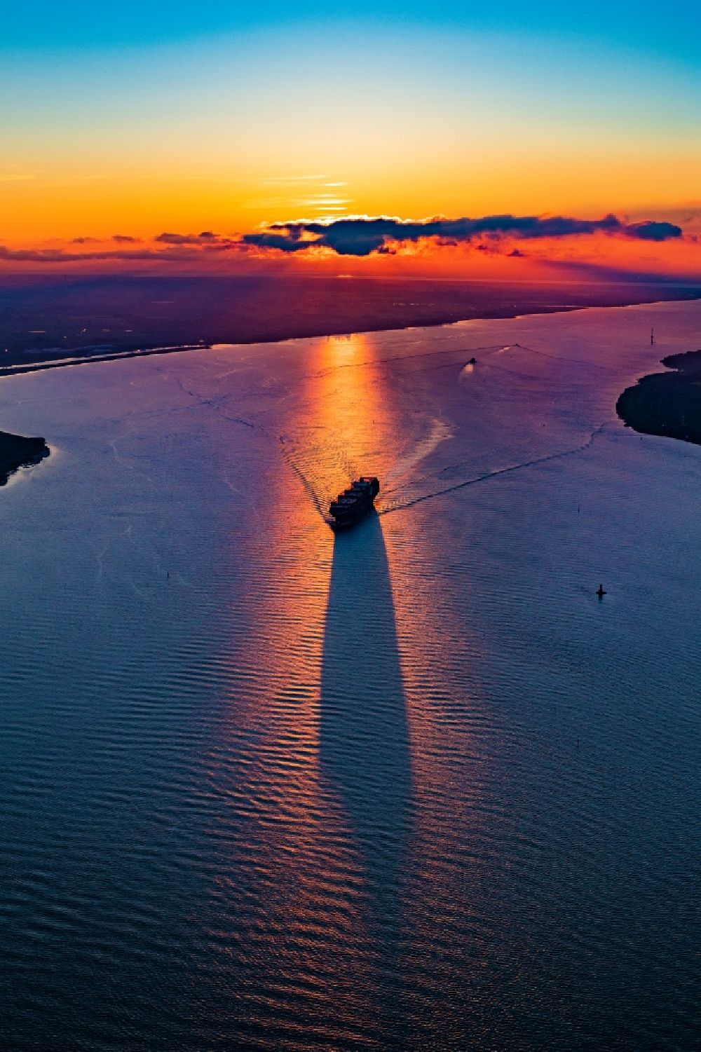 Aerial photograph Kollmar - Sailing container ship at the Elbe river during sunset in Kollmar, Germany