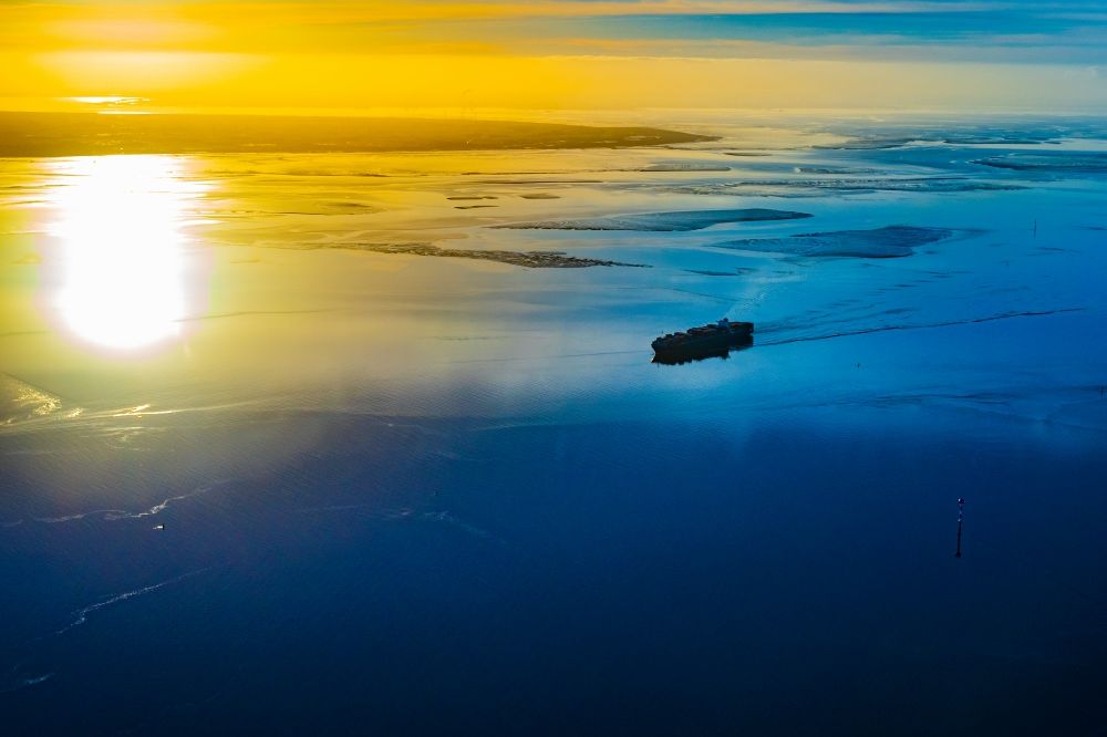 Aerial photograph Butjadingen - Moving container ship Maribor Maersk in the sunset in the Weser estuary in Butjadingen in the state Lower Saxony, Germany