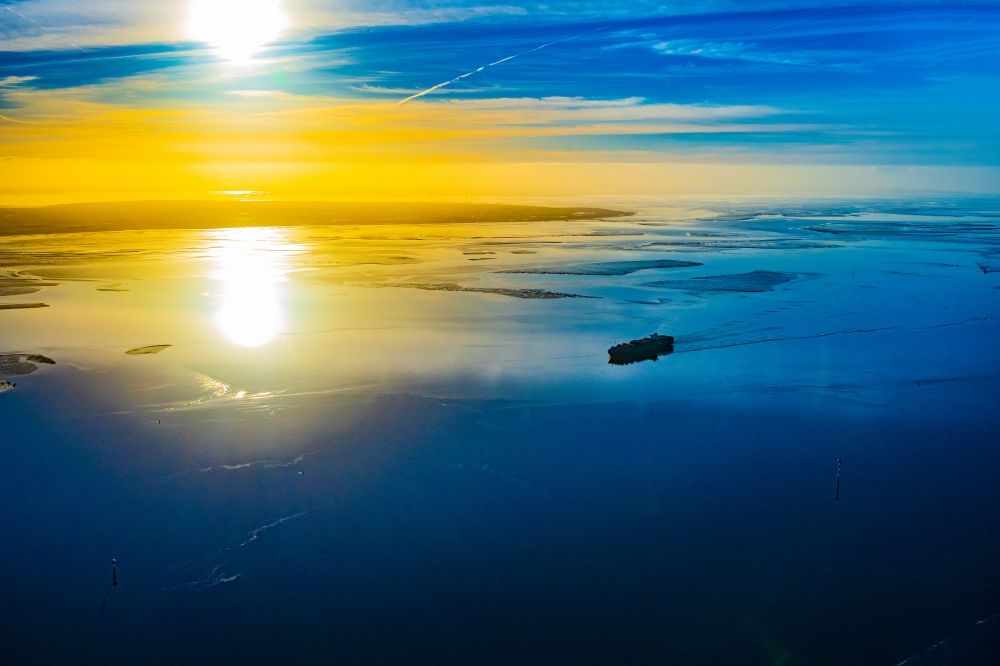 Butjadingen from above - Moving container ship Maribor Maersk in the sunset in the Weser estuary in Butjadingen in the state Lower Saxony, Germany