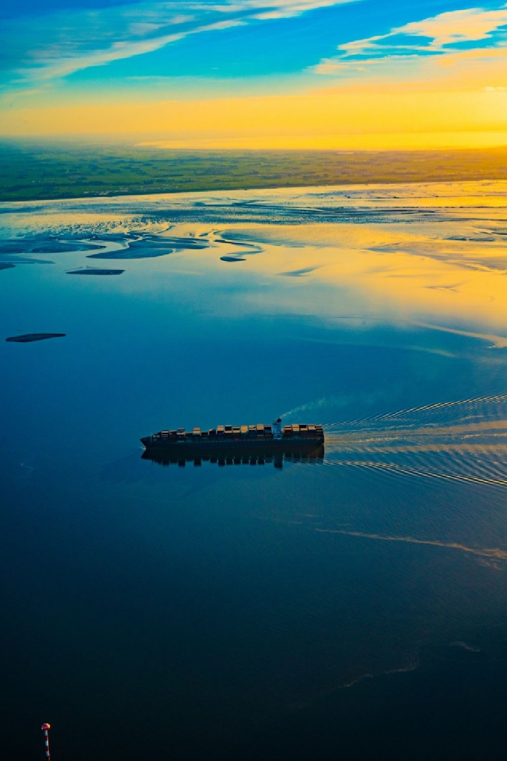 Aerial image Butjadingen - Moving container ship Maribor Maersk in the sunset in the Weser estuary in Butjadingen in the state Lower Saxony, Germany