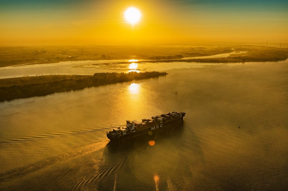 Stade from above - Sailing container ship in fog Layer on Elbe river course in Drochtersen in the state Lower Saxony, Germany