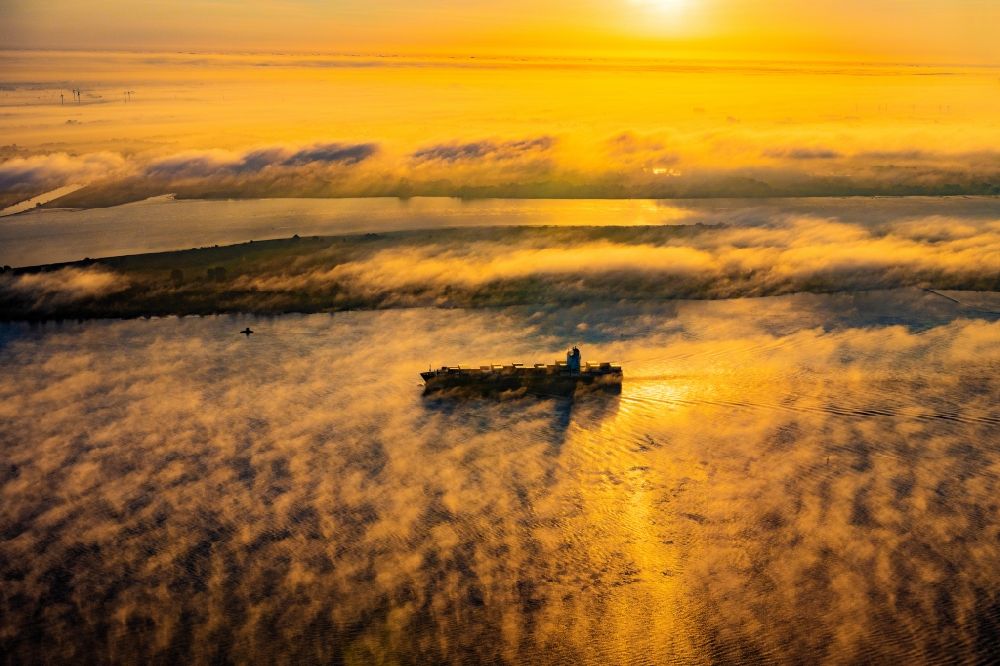Aerial image Kollmar - Voyage of a container ship of the SEASPAN DALIAN IMO: 9227027 in a layer of fog at sunrise on the course of the Elbe river in Kolmar in the state Schleswig-Holstein, Germany