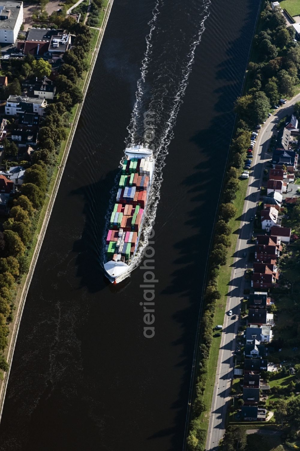 Rendsburg from the bird's eye view: Sailing container ship on Nord-Ostsee-Kanal in Rendsburg in the state Schleswig-Holstein, Germany