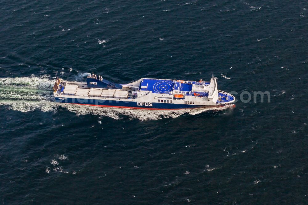 Strande from above - Travel of a ferry ship on the Baltic Sea entering the Kiel Fjord in Strande in the state Schleswig-Holstein, Germany. The freight ferry ATHENA SEAWAYS ( IMO 9350680 ) of the shipping company DFDS runs shuttle services between Kiel and Lithuania