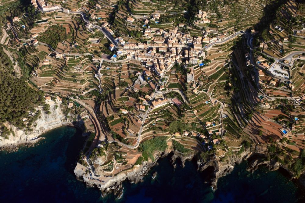 Aerial image Banyalbufar - Rock Coastline on the cliffs with stepped roads and residential areas in Banyalbufar in Balearic Islands, Spain