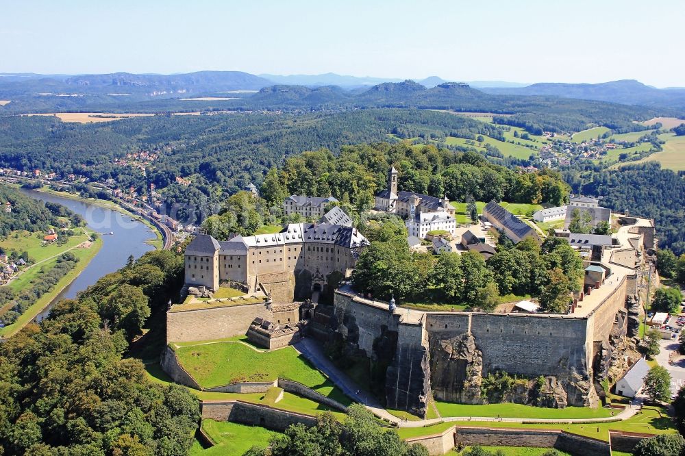 Königstein from the bird's eye view: The Fortress Koenigstein at the river Elbe in the county district of Saxon Switzerland East Erzgebirge in the state of Saxony. The fortress is one of the largest mountain fortresses in Europe and is located amidst the Elbe sand stone mountains on the flat top mountain of the same name. In front of it, the river runs through a valley