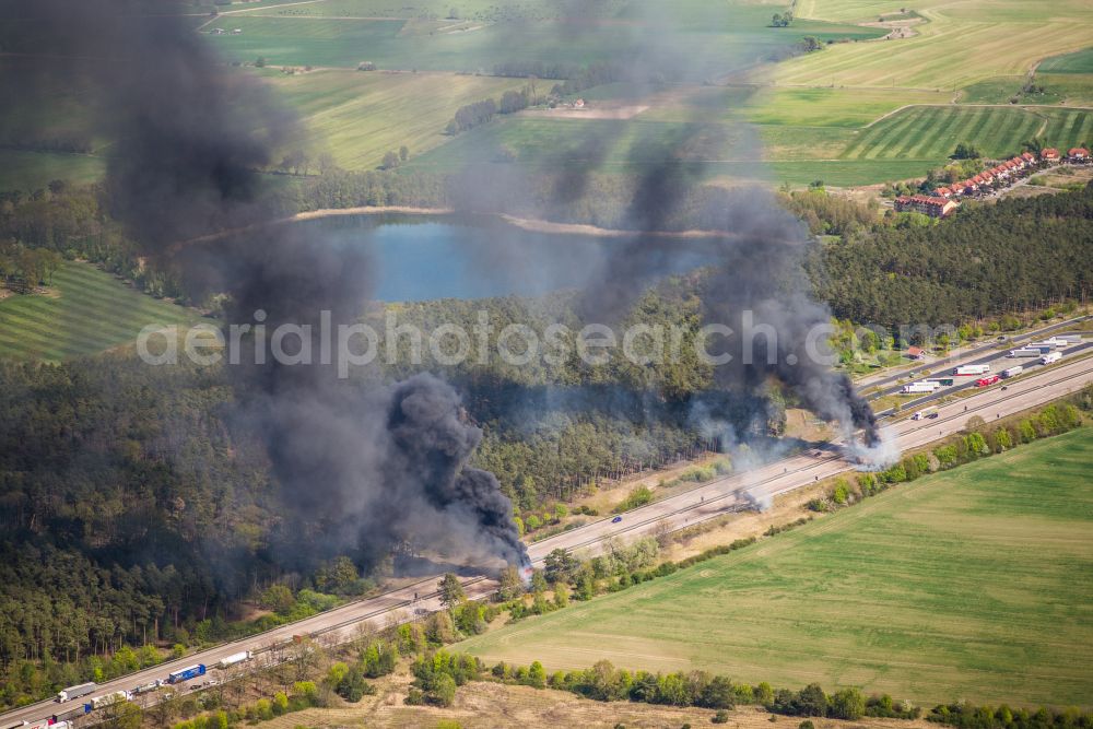 Aerial photograph Netzen - Accident damage to a truck burning with clouds of black smoke in road traffic along the Autobahn BAB A2 in Netzen in the state Brandenburg, Germany