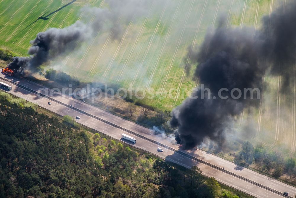 Netzen from the bird's eye view: Accident damage to a truck burning with clouds of black smoke in road traffic along the Autobahn BAB A2 in Netzen in the state Brandenburg, Germany