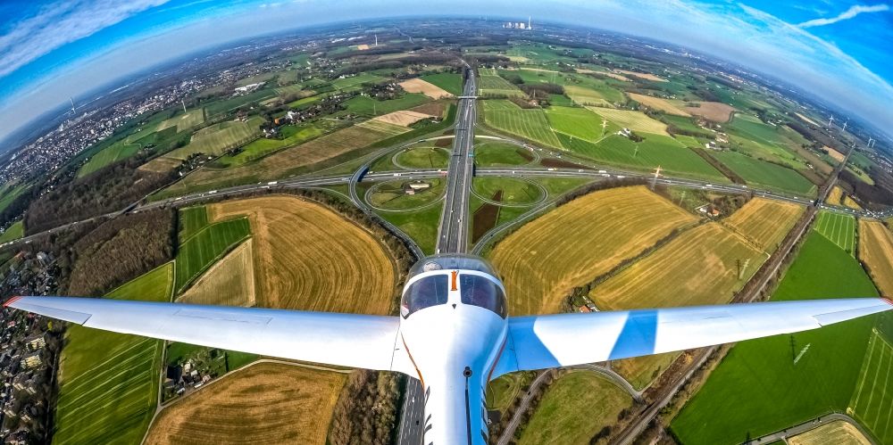 Kamen from the bird's eye view: Fisheye perspective motorglider in flight over the traffic flow at the intersection- motorway A 1 A2 Kamener Kreuz in Kamen in the state North Rhine-Westphalia, Germany