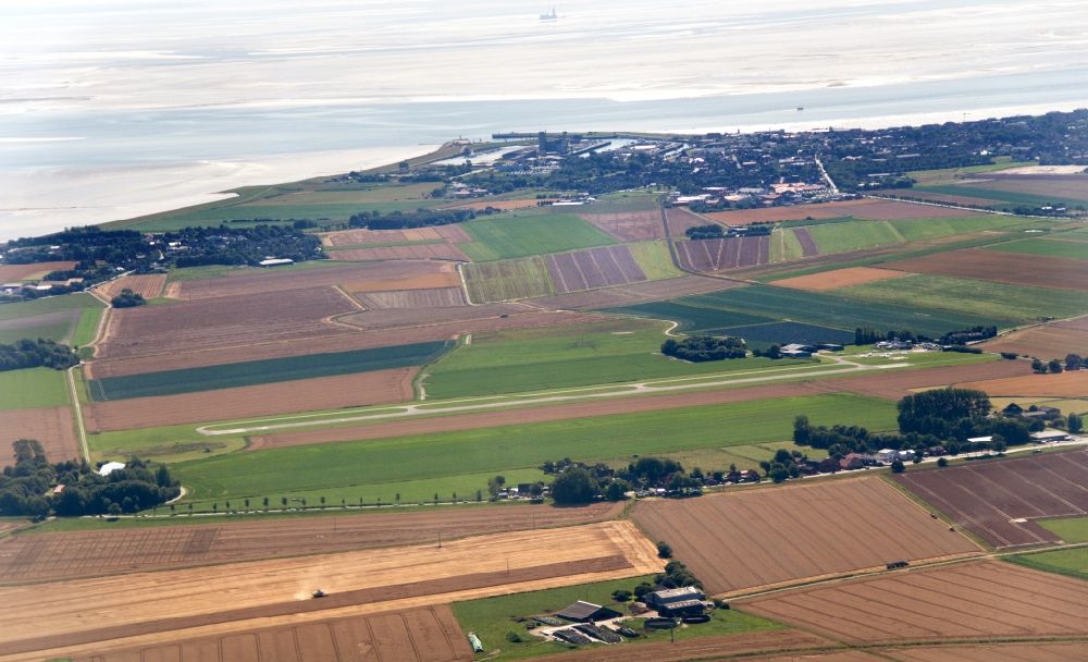 Aerial image Büsum - Runway with tarmac terrain of airfield Heide-Buesum in Buesum in the state Schleswig-Holstein performing low approach
