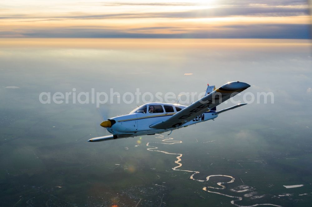 Deinste from the bird's eye view: Aircraft PA-28R-200 Arrow II in flight above in Deinste in the state Lower Saxony, Germany