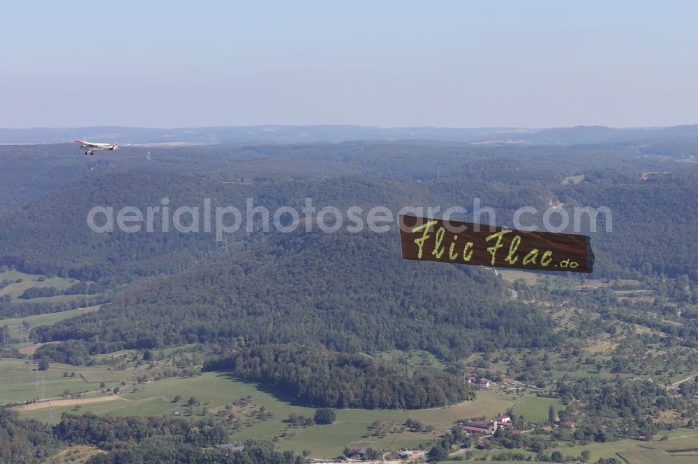 Reutlingen from the bird's eye view: Aircraft D-ECPD - Piper PA-28 with banner towing for the circus Flic Flac the fly over the airspace in Reutlingen in Baden-Wuerttemberg