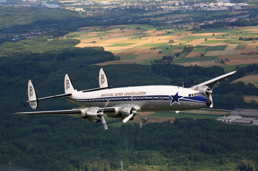 Möhlin from the bird's eye view: Lockheed L1049 Super Constellation Aircraft in flight in the airspace over Moehlin in Switzerland. The Breitling Super Constellation is one of yet only two flying aircraft in the world of this legendary airliner and belongs to the Super Constellation Flyers Association at the Euroairport in Basle