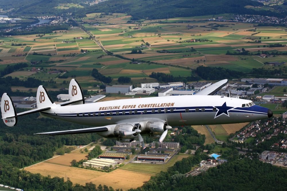 Möhlin from the bird's eye view: Lockheed L1049 Super Constellation Aircraft in flight in the airspace at Moehlin in Switzerland. The Breitling Super Constellation is one of yet only two flying aircraft in the world of this legendary airliner and belongs to the Super Constellation Flyers Association at the Euroairport in Basle