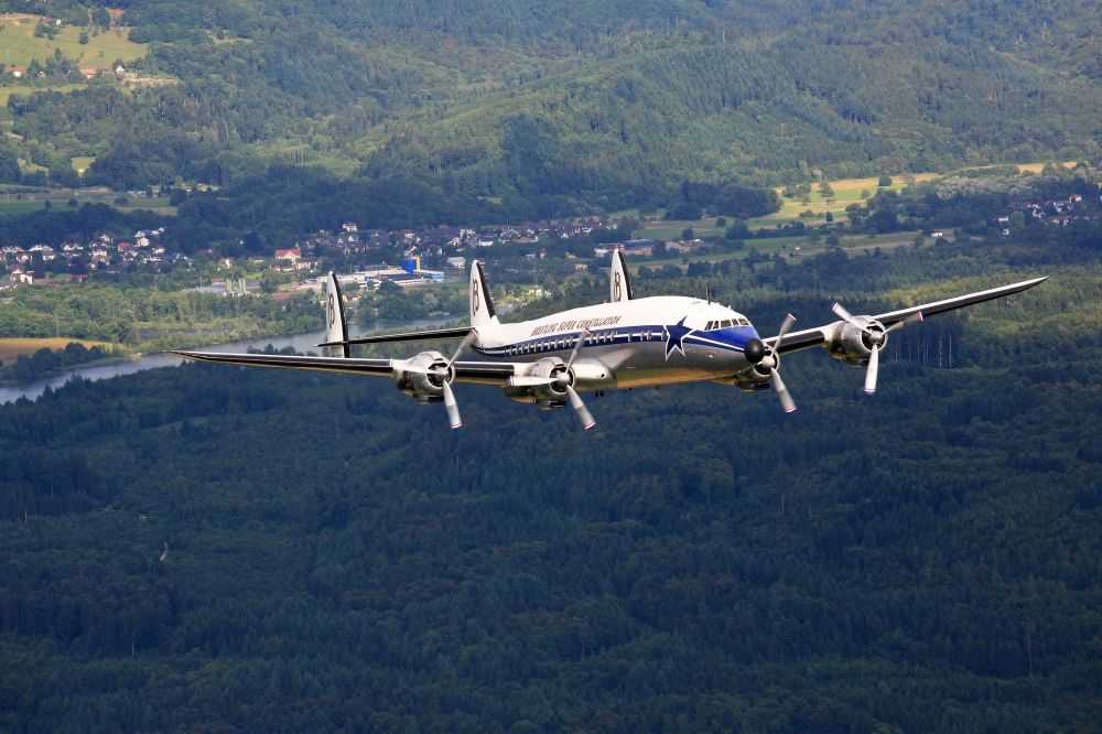 Wehr from above - Lockheed L1049 Super Constellation Aircraft in flight in the airspace over Wehr in the state Baden-wurttemberg. The Breitling Super Constellation is one of yet only two flying aircraft in the world of this legendary airliner and belongs to the Super Constellation Flyers Association at the Euroairport in Basle