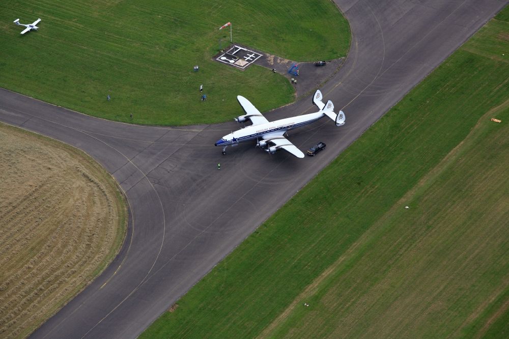 Aerial photograph Eschbach - Lockheed L1049 Super Constellation Aircraft visiting the Airport Bremgarten in Eschbach in the state Baden-wurttemberg. The Breitling Super Constellation is one of yet only two flying aircraft in the world of this legendary airliner and belongs to the Super Constellation Flyers Association at the Euroairport in Basle