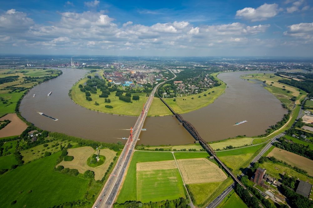 Duisburg from the bird's eye view: River - bridge construction - A42 highway bridge and railway bridge over the Rhine in Duisburg in North Rhine-Westphalia